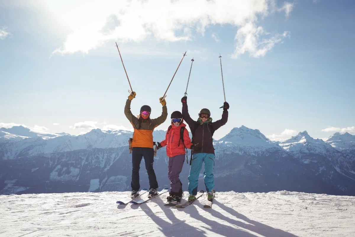 Skifahrer feiern auf einem schneebedeckten Gipfel in der Schweiz – perfekte Kulisse für eSIM-Nutzer beim Reisen