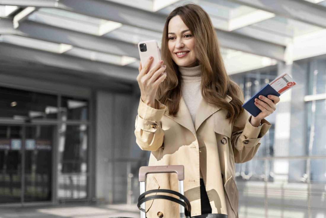 Junge Frau im Mittelportrait hält Smartphone in der Hand und nutzt mobile Daten über eSIM Schweiz